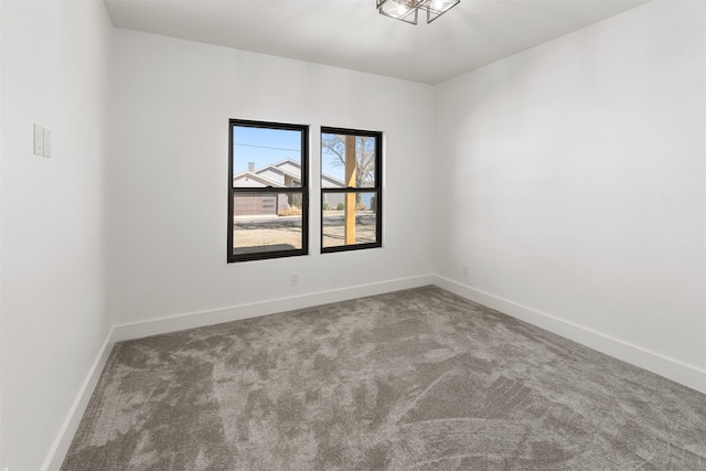 spare room featuring carpet and baseboards