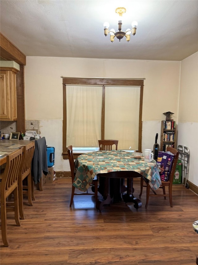 dining area featuring a chandelier and dark wood-type flooring