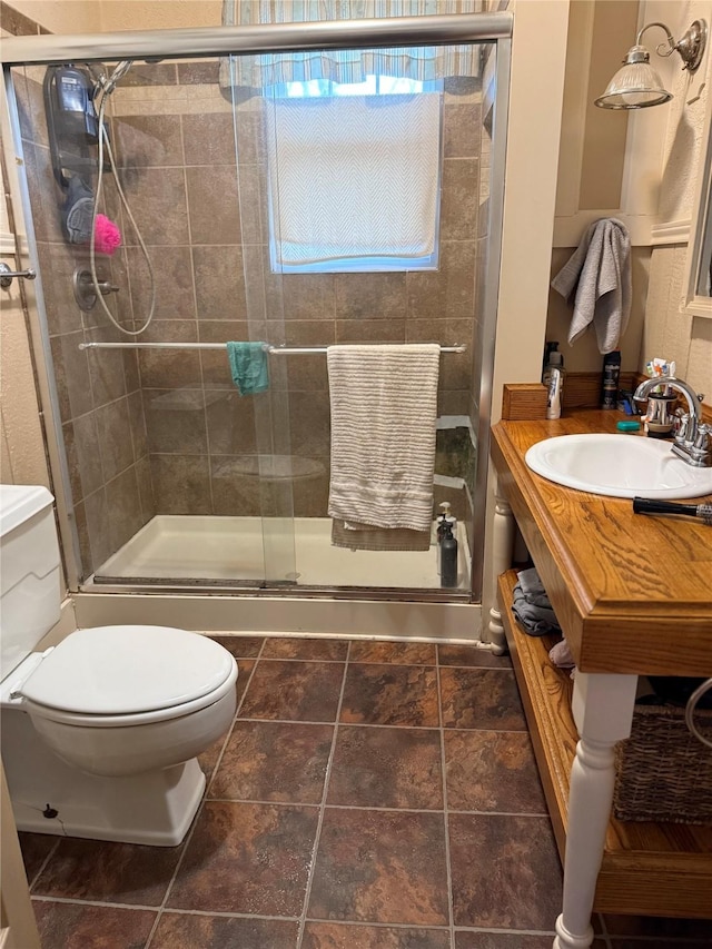 bathroom featuring vanity, a shower stall, and toilet