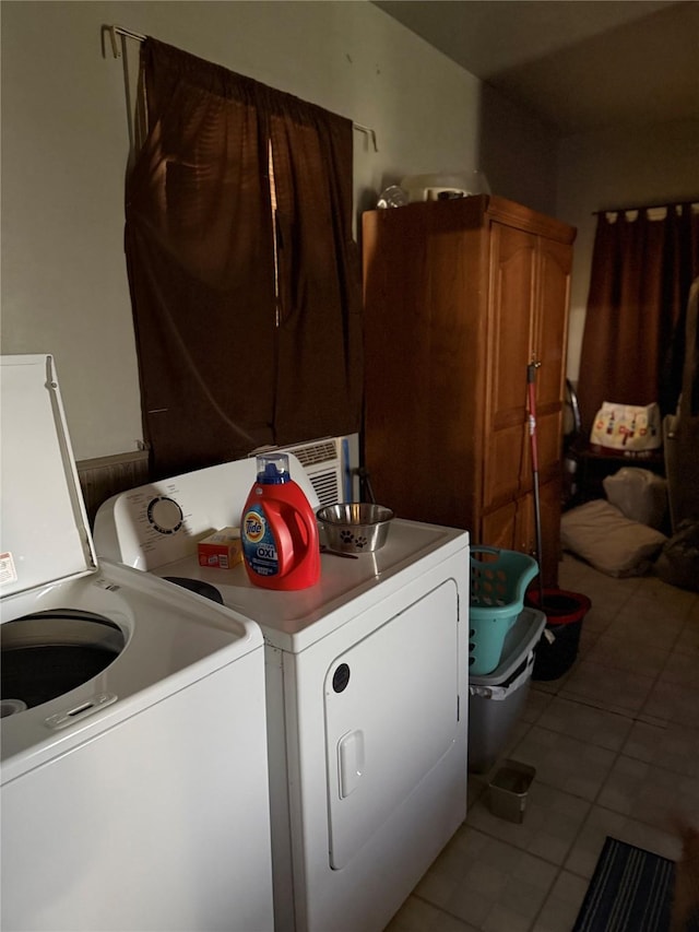 washroom featuring cabinet space, washing machine and dryer, and tile patterned floors