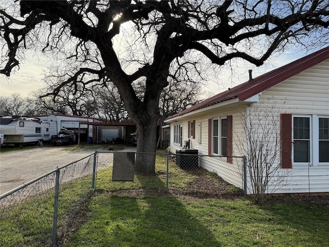 exterior space featuring a yard, an outbuilding, metal roof, and fence