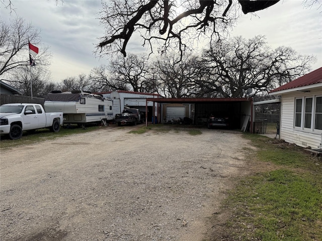 exterior space with driveway, a detached garage, and an outdoor structure