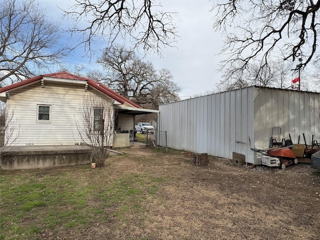 view of home's exterior featuring an outbuilding, metal roof, a carport, and a pole building