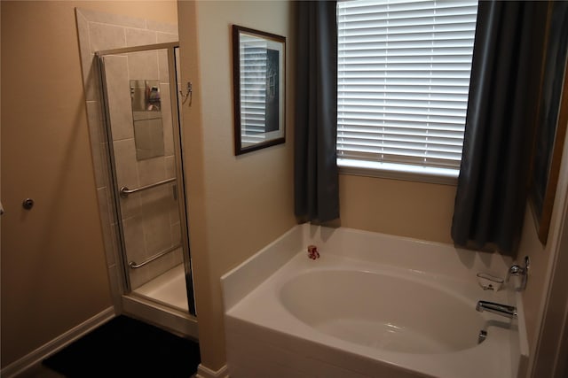 bathroom featuring a stall shower and a bath