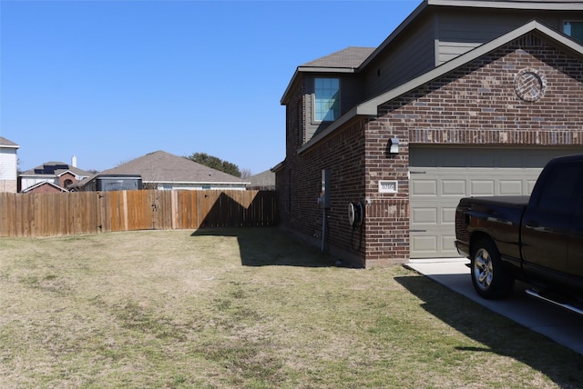 view of side of property with a garage, brick siding, a lawn, and fence