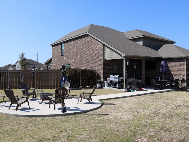 back of property with brick siding, a patio, and a lawn