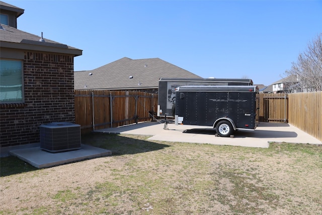 view of yard featuring a fenced backyard, a patio, and central AC unit