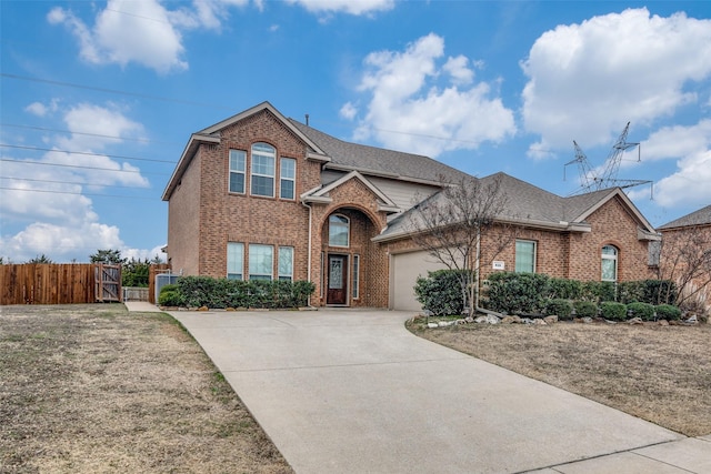 traditional home featuring a gate, brick siding, driveway, and an attached garage