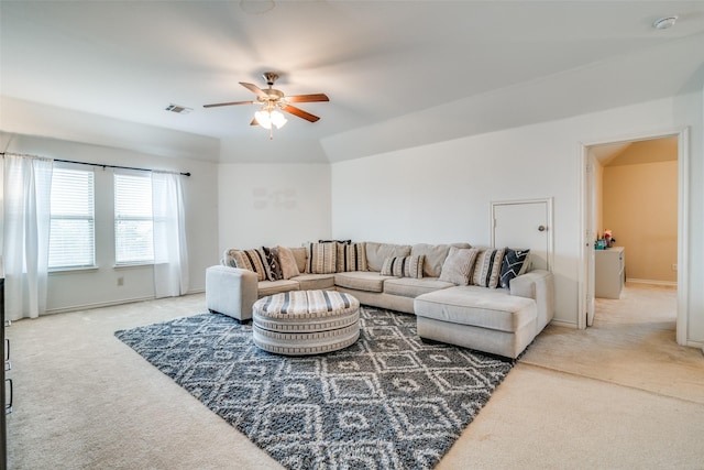 living area featuring a ceiling fan, visible vents, light carpet, and baseboards