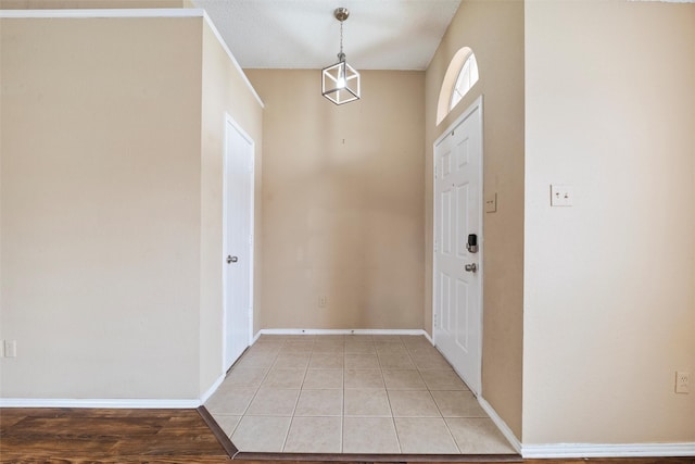 foyer with light tile patterned flooring and baseboards