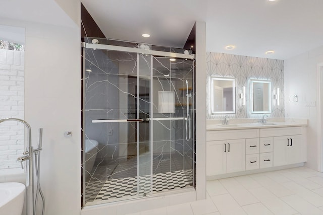 bathroom featuring a freestanding tub, a sink, a shower stall, and double vanity