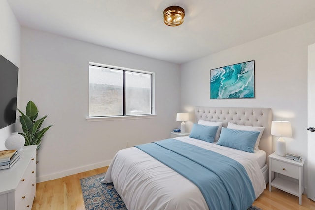 bedroom with light wood-type flooring and baseboards