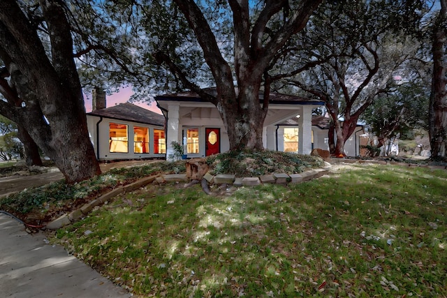 view of front of house featuring a chimney and a front lawn