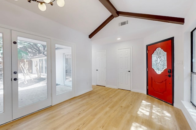 foyer entrance with vaulted ceiling with beams, baseboards, visible vents, and wood finished floors