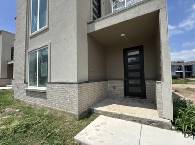 9475 Timberleaf Dr, Dallas, TX 75243 - property entrance featuring brick siding, stucco siding, and a balcony