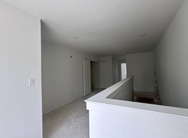 9475 Timberleaf Dr, Dallas, TX 75243 - corridor featuring unfinished concrete floors and an upstairs landing