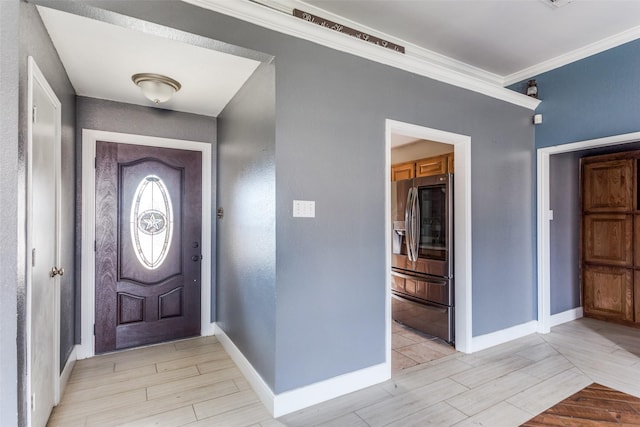 foyer entrance featuring baseboards, crown molding, and wood finish floors