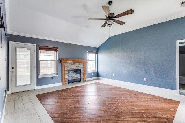 unfurnished living room featuring visible vents, a fireplace with flush hearth, wood finished floors, vaulted ceiling, and crown molding