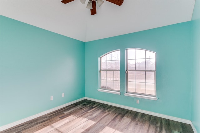 spare room with lofted ceiling, ceiling fan, baseboards, and wood finished floors