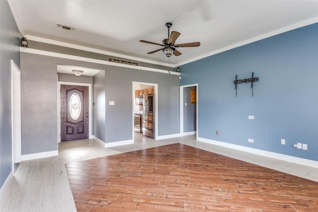 entryway featuring a ceiling fan, visible vents, crown molding, and wood finished floors