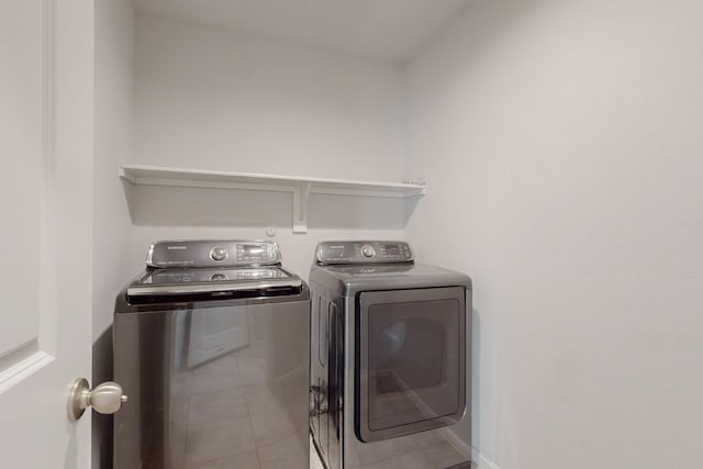 laundry room featuring tile patterned flooring, laundry area, and washing machine and clothes dryer