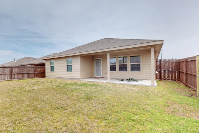 rear view of property with a fenced backyard, a lawn, and a patio