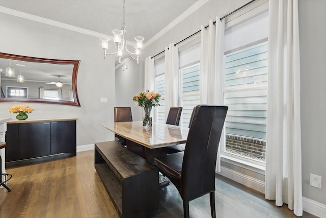 dining space featuring baseboards, a chandelier, wood finished floors, and crown molding