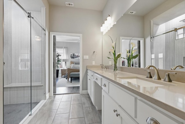 ensuite bathroom with visible vents, a sink, and a shower stall