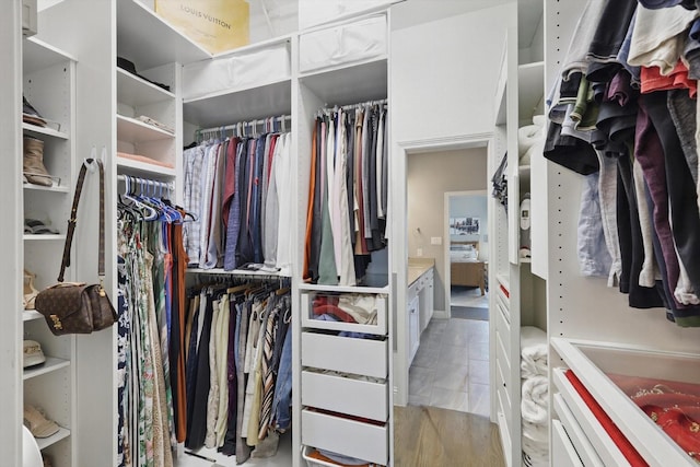 walk in closet with wood finished floors