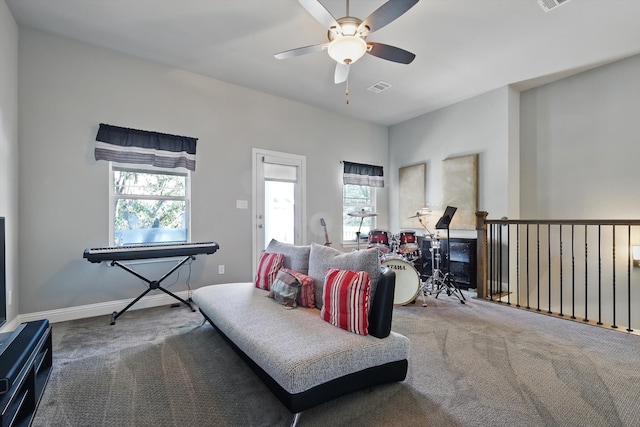 living area featuring ceiling fan, plenty of natural light, carpet flooring, and visible vents