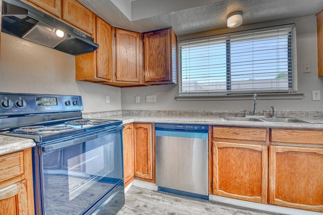 kitchen with black electric range oven, light wood-style flooring, under cabinet range hood, dishwasher, and a sink