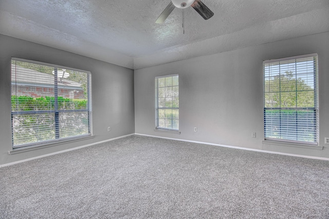 unfurnished room featuring carpet flooring, a textured ceiling, baseboards, and ceiling fan