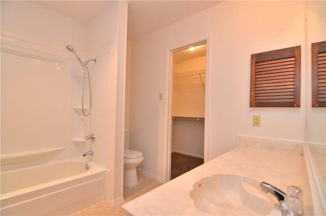 bathroom with toilet, vanity, baseboards, a spacious closet, and washtub / shower combination