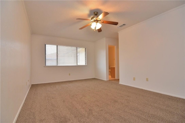 spare room featuring light carpet, baseboards, and crown molding