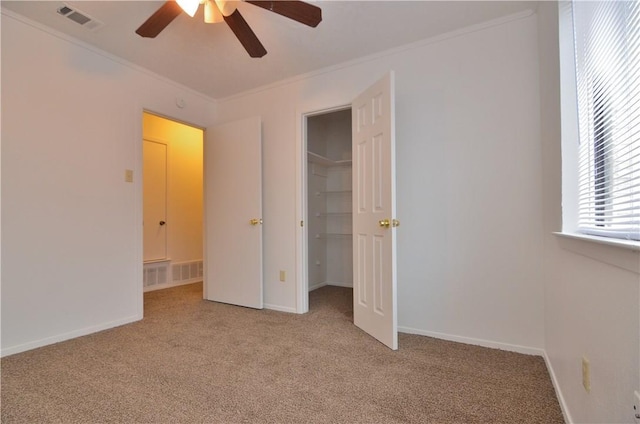 unfurnished bedroom with light carpet, ornamental molding, visible vents, and baseboards