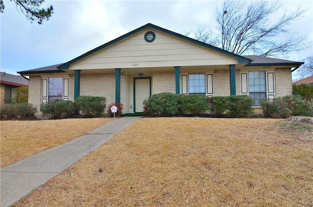 single story home featuring brick siding and a front lawn