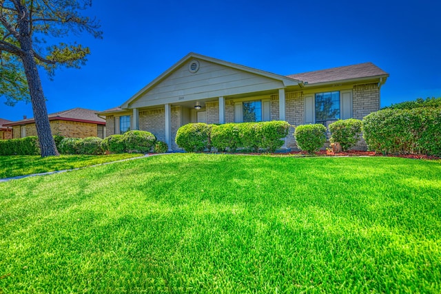 ranch-style house featuring a front lawn and brick siding