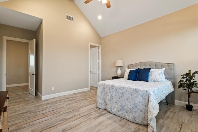 bedroom featuring high vaulted ceiling, visible vents, baseboards, and wood finished floors