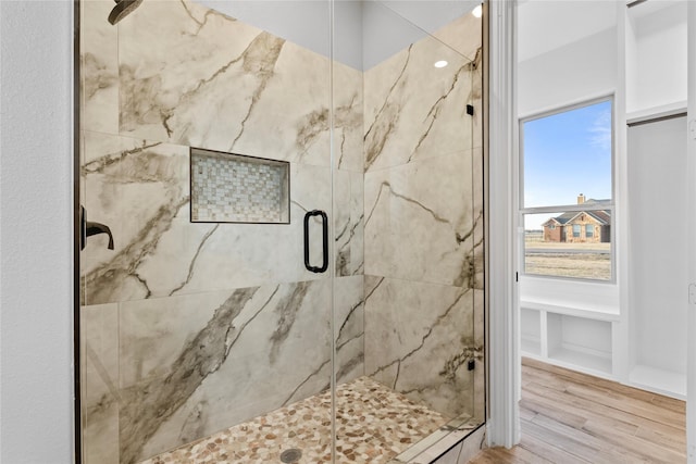 full bathroom with wood finished floors and a marble finish shower