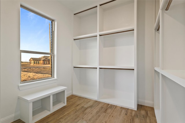 walk in closet with wood finished floors