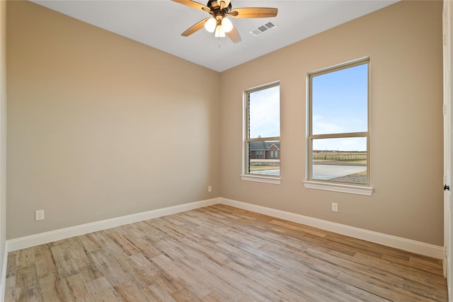 unfurnished room with visible vents, ceiling fan, light wood-style flooring, and baseboards