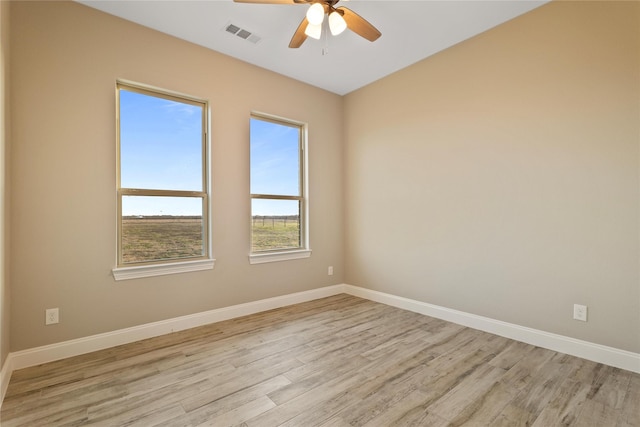 unfurnished room with a ceiling fan, light wood-style flooring, visible vents, and baseboards