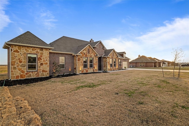 view of front facade featuring stone siding, a shingled roof, a chimney, and a front yard