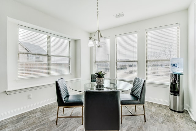 dining area featuring a healthy amount of sunlight, visible vents, and wood finished floors