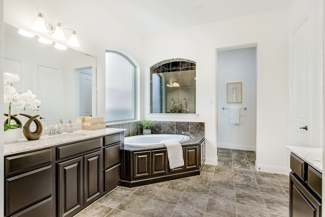 bathroom featuring a garden tub, a tile shower, and vanity