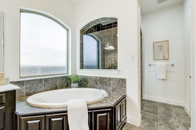 full bathroom with visible vents, a tile shower, baseboards, and a bath