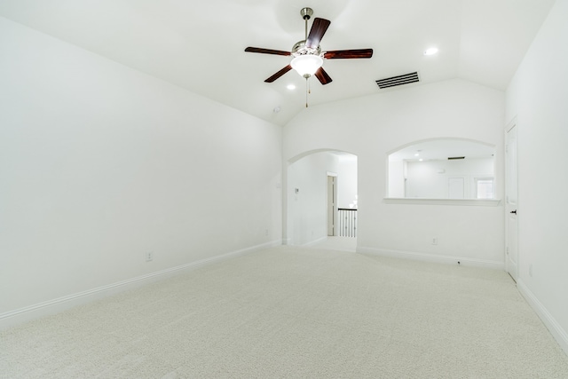 carpeted empty room with lofted ceiling, arched walkways, recessed lighting, visible vents, and baseboards