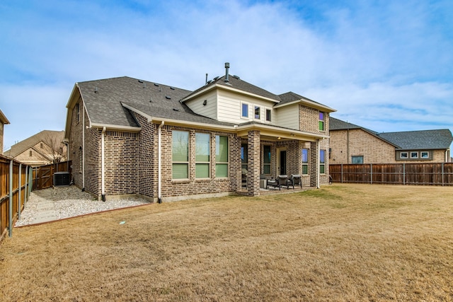 back of property featuring brick siding, a patio, a lawn, central AC, and a fenced backyard