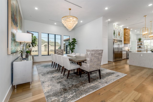 dining space featuring an inviting chandelier, light wood-style flooring, recessed lighting, and baseboards