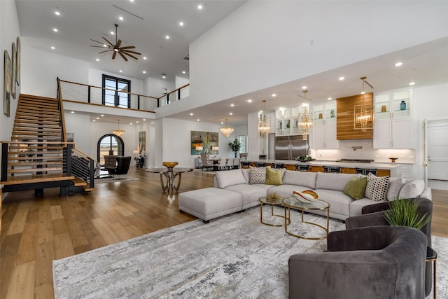 living room with recessed lighting, a ceiling fan, wood finished floors, and stairs